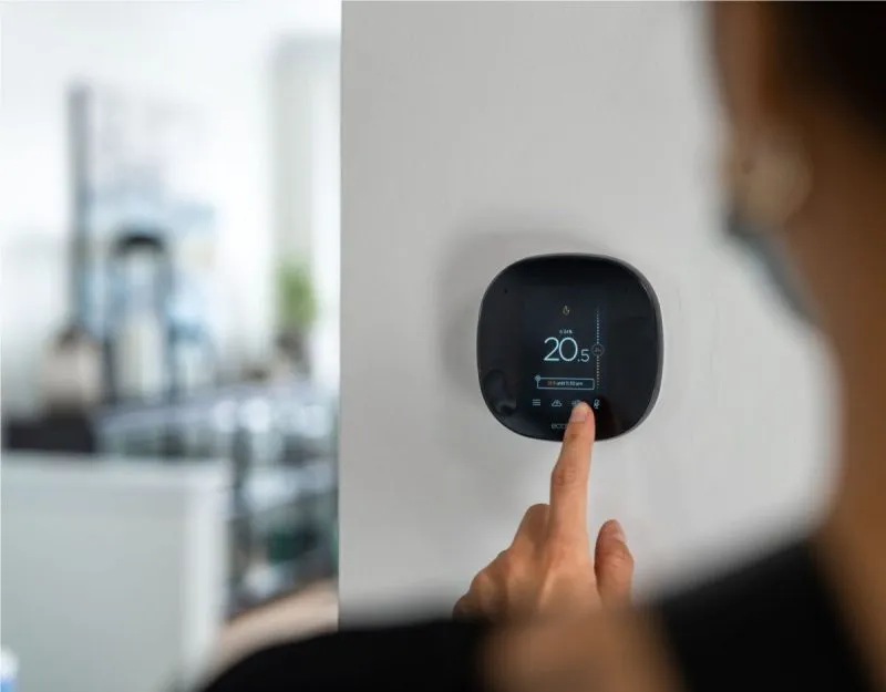 Smart thermostat being adjusted inside a new Upper Joshua Creek home