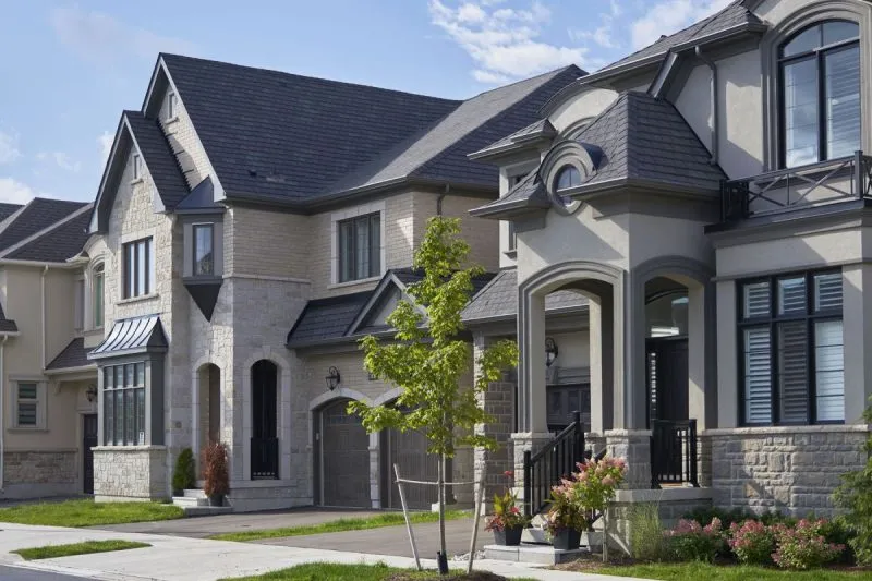 Detached homes with stone and brick elevations on a street in Upper Joshua Creek